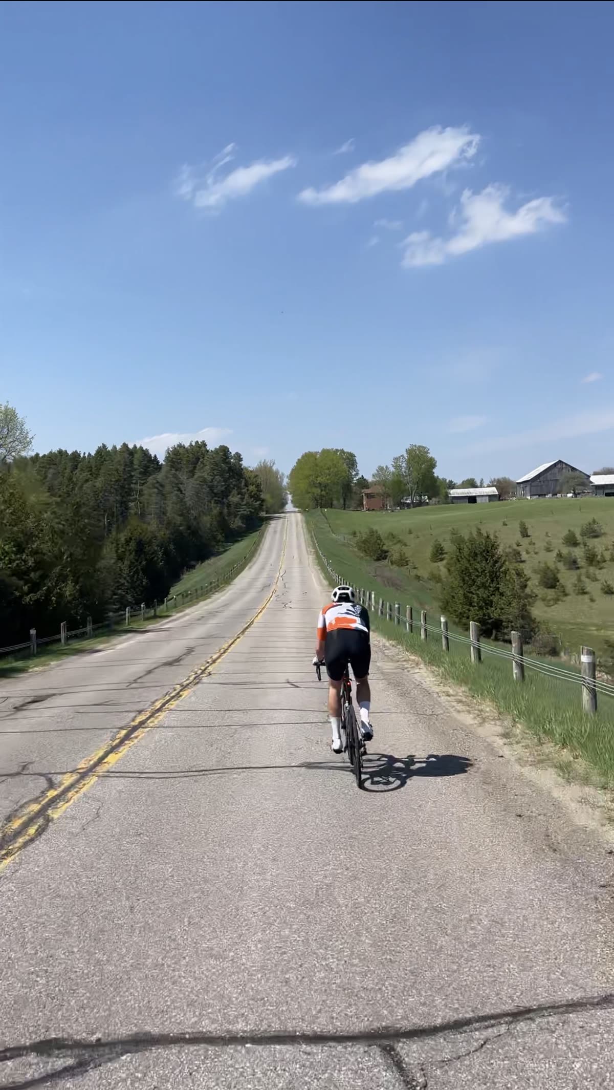 Cyclist climbing a quiet rolling country road in the Hockley Valley