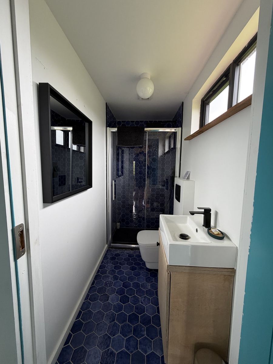 The cabin's blue-tiled bathroom with a walk-in shower