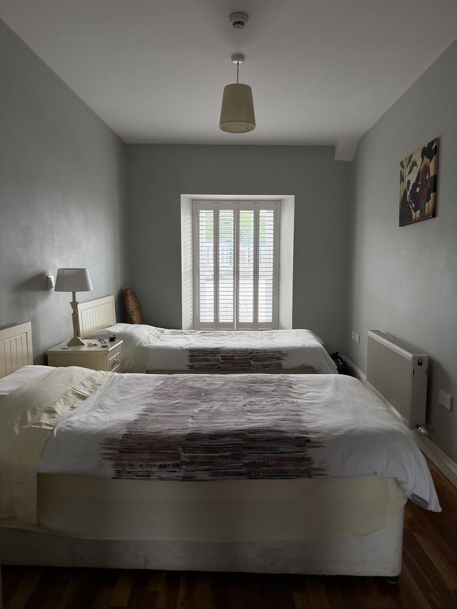 The B&B bedroom with two neatly made beds and a shuttered window