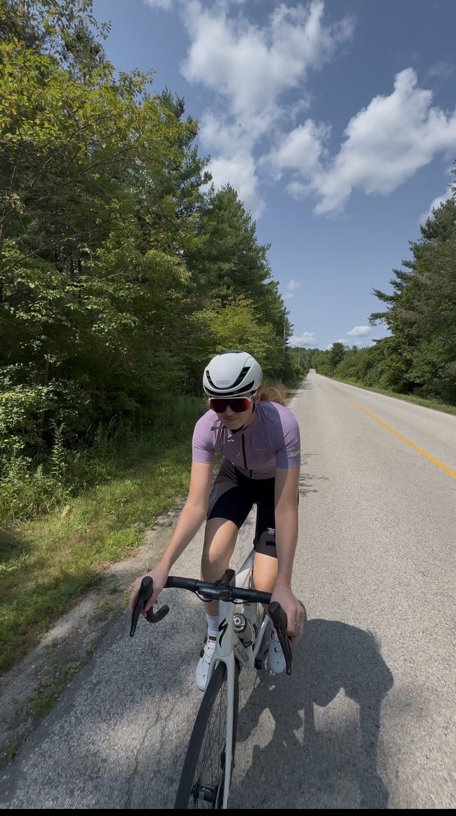 Bailey riding toward the camera on a tree-lined road in Puslinch