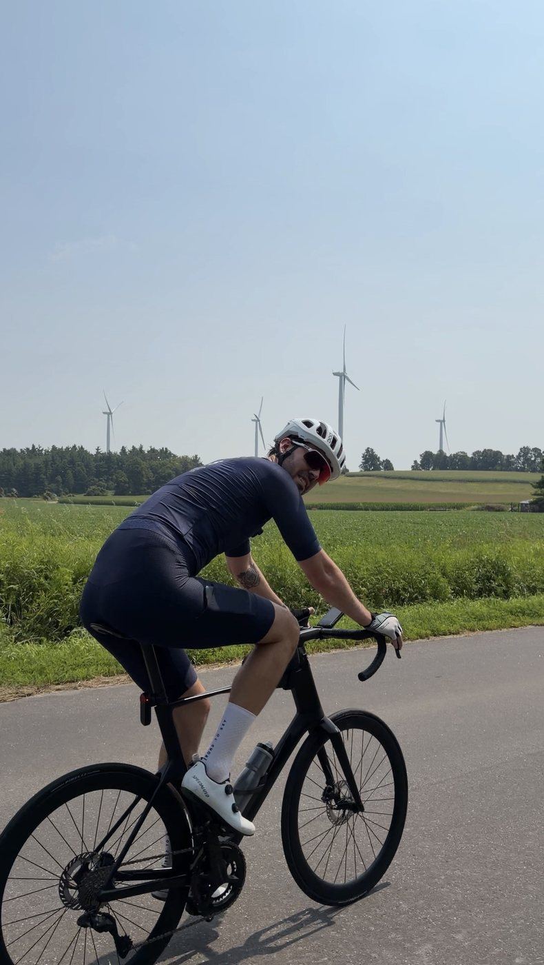 Francis riding past a field of wind turbines on a farm road north of Port Hope