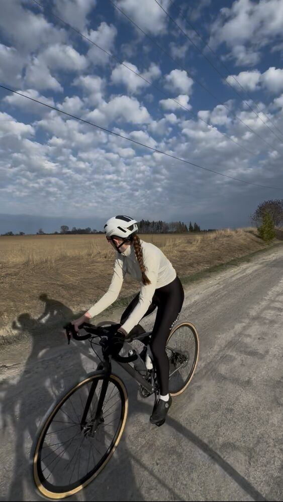 Rider on a gravel concession road under a big cloud sky